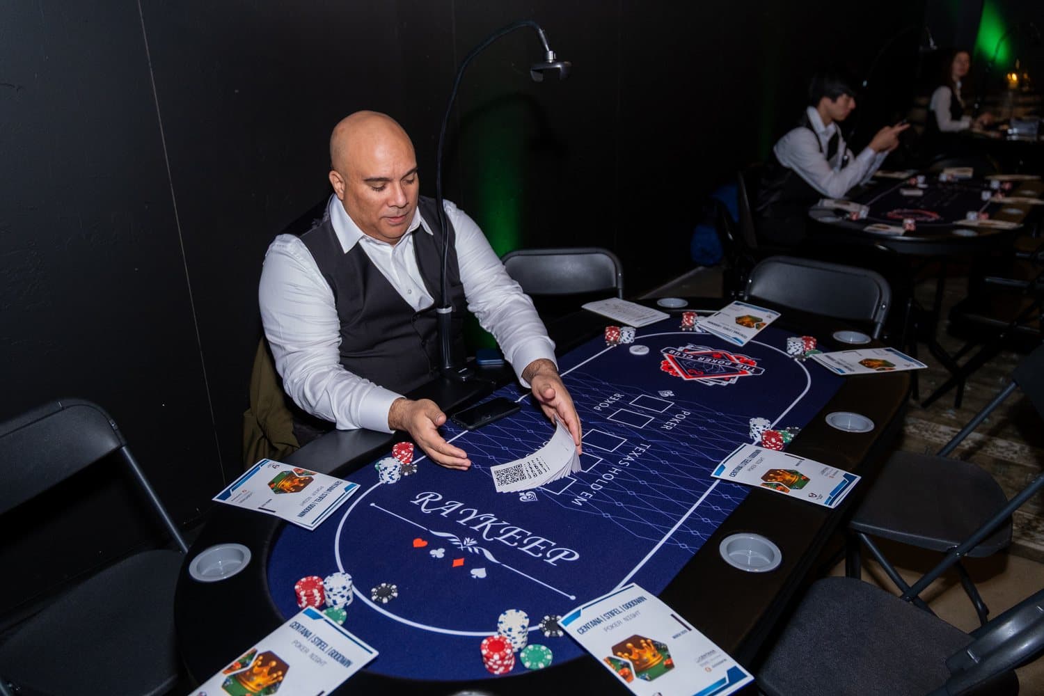 A Full House Vision dealer fanning the deck at a fully set poker table