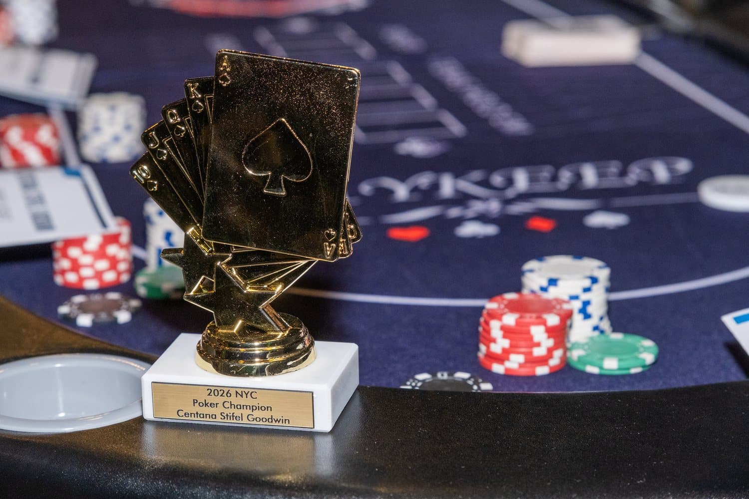 The champion's trophy on a poker table beside stacks of chips