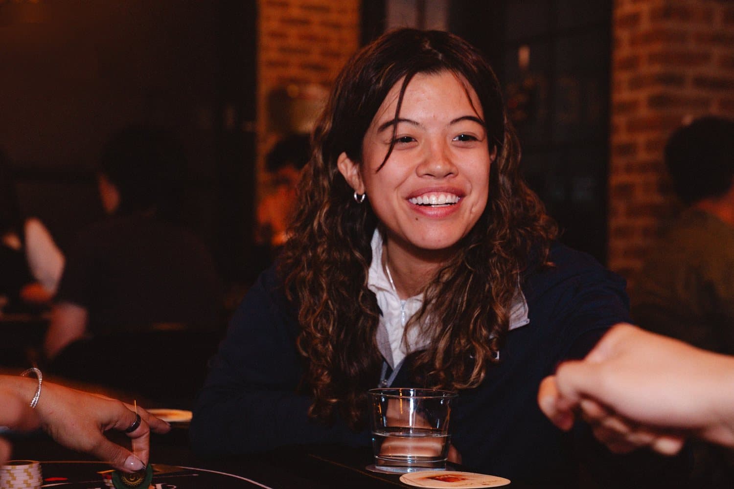 A guest laughing at the poker table during a Full House Vision event